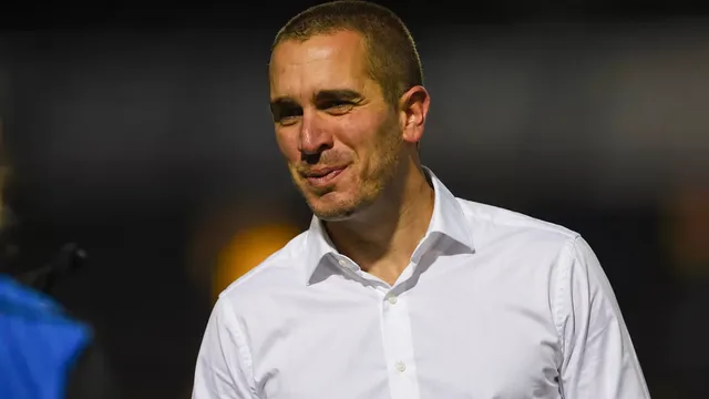 Nick Bochette in a white shirt under stadium lights